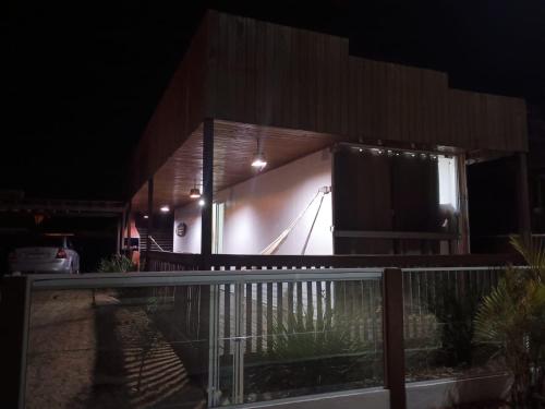 a lit up building at night with a pool at Casa container in São Lourenço do Sul