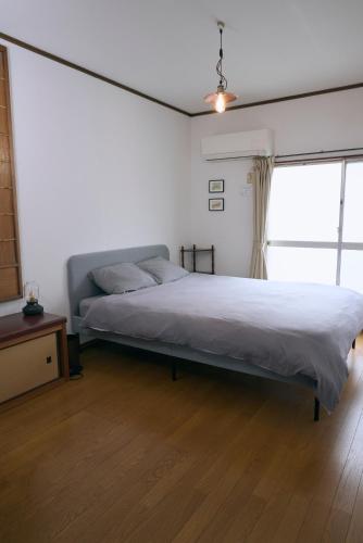 a bedroom with a bed and a large window at A cozy home between Osaka and Kyoto -UNiCO- in Takatsuki