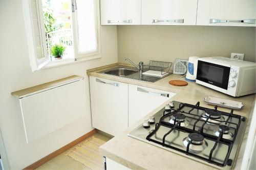 a kitchen with a stove top oven next to a microwave at Nanda house in Piove di Sacco