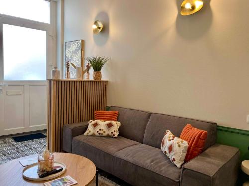 ein Wohnzimmer mit Sofa und Tisch in der Unterkunft Maison 2 chambres avec bureau - Proche gare in Saint-Omer
