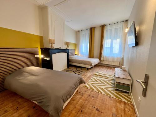 ein Schlafzimmer mit einem Bett und einer Couch in der Unterkunft Maison 2 chambres avec bureau - Proche gare in Saint-Omer