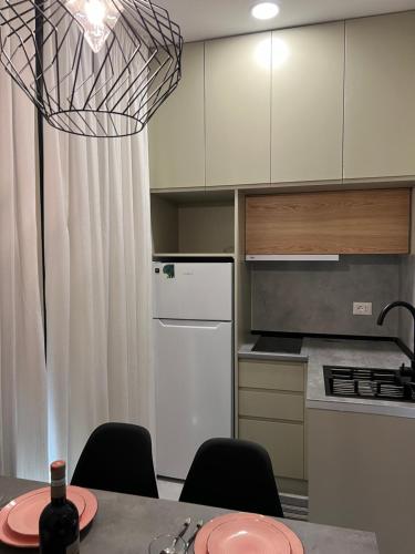 a kitchen with a table with chairs and a white refrigerator at Liams Cozy Villa in Korçë