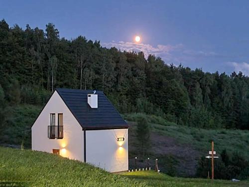a small white chapel with the moon in the background at MotoChillout in Polańczyk