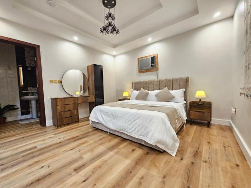 a bedroom with a large bed and a chandelier at comfort suite in Jeddah
