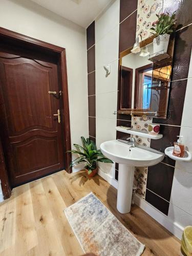 a bathroom with a sink and a brown door at comfort suite in Jeddah