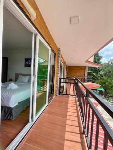a balcony with a bedroom and a bed on it at Lucky 9 Airport Hotel Phuket in Nai Yang Beach