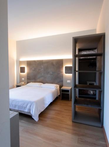 a bedroom with a bed and a book shelf at Hotel Meeting in Stresa