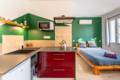 eine Küche mit einem Bett und einem Waschbecken in einem Zimmer in der Unterkunft L'étape Arlésienne in Arles