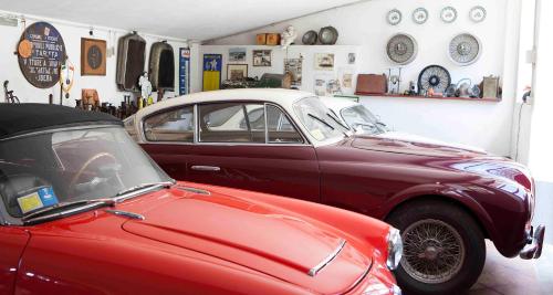 two old cars are parked in a garage at Fattoria Poggio Capponi in Montespertoli