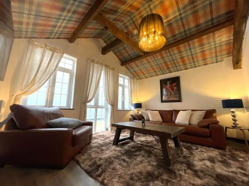 a living room with a couch and a table at Balmoral Lodge, King Size Apartment by The Hive WA1 in Warrington