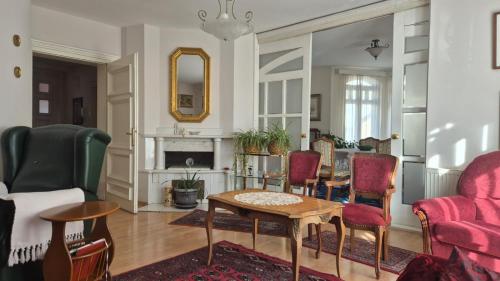 a living room with red chairs and a table at Big & Bright City Center Apartment in Užice