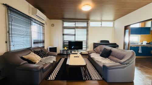 a living room with two couches and a coffee table at 小樽の温もり一棟貸し in Otaru