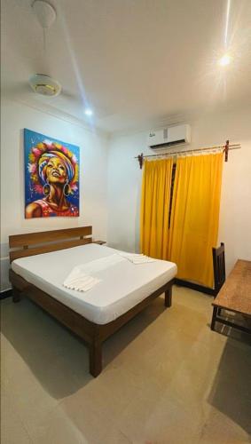 a bedroom with a bed and a painting on the wall at Lemon Lodge Nungwi in Nungwi