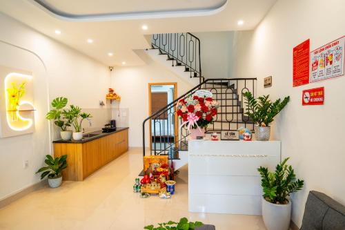 a living room with a staircase and plants at Dimori homestay in Thôn Trường Giang