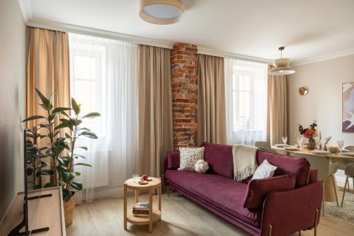 a living room with a purple couch and a table at Red Roof Apartments Old Town in Krakow