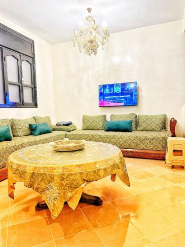 un salon avec une table et un canapé dans l'établissement Calm & Comfortable Tafraout Apartment for families Ground Floor, à Tafraout