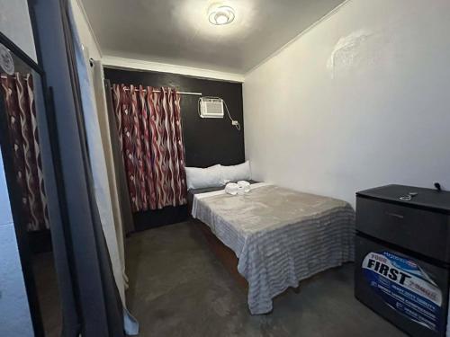 a small room with a bed and a television at Dean's Homestay Siargao in General Luna