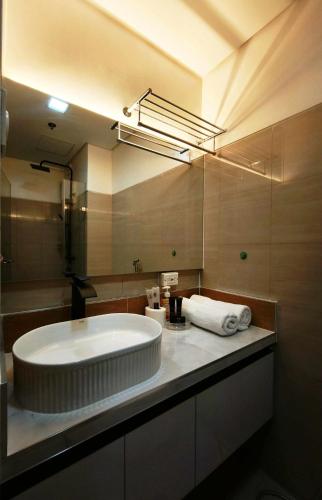 a bathroom with a large sink and a large mirror at Sithonia Suite, Shore Residences Tower C near MOA in Manila