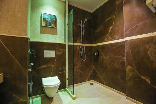 un bagno con wc e doccia in vetro di HOTEL KAVERI , a boutique hotel a Zirakpur