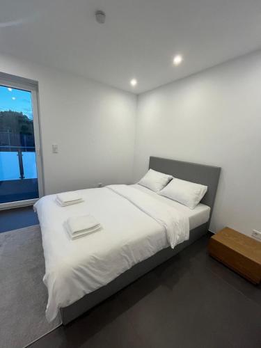 a bedroom with a bed with white sheets and a window at Modern new-build apartment in Groß-Gerau
