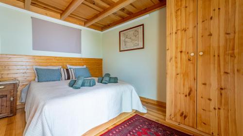 a bedroom with a white bed and wooden walls at The Goat's Place III in Gaula
