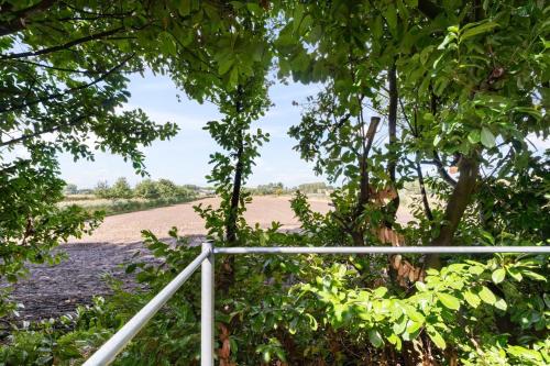 uma cerca com árvores e um campo ao fundo em Chalet & Spa Nora em Stekene