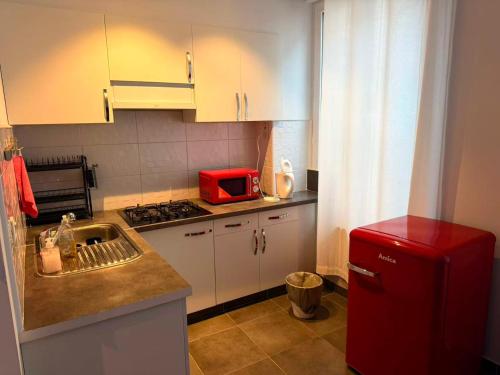 a kitchen with a sink and a red microwave at Sweet Dream House in Brussels