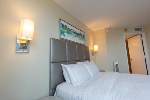 a bedroom with a large white bed with white pillows at Luxury Waterfront Condo Hilton Hotel Amenities Beach Pool Jacuzzi Jetskis Gym in Fort Lauderdale