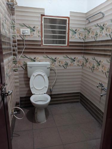 a bathroom with a toilet and a window at SHREVIK Comforts in Chikmagalūr