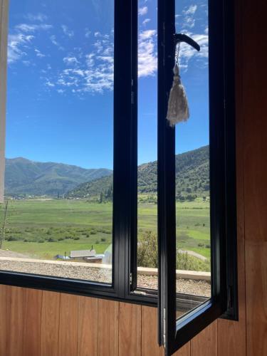 a window with a view of a green field at El filo del Lolog in San Martín de los Andes