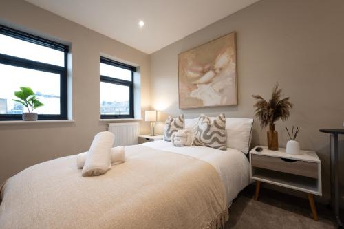 a bedroom with a large white bed and two windows at Stylish 2BR Retreat - Sleeps 6 - Central Chatham in Chatham