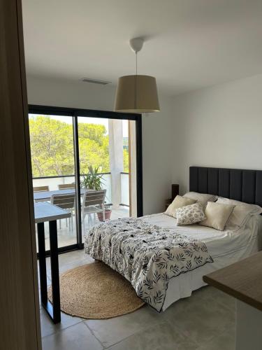 une chambre avec un lit, une table et une fenêtre dans l'établissement Au Pied du Pic Saint Loup, à Saint-Mathieu-de-Tréviers