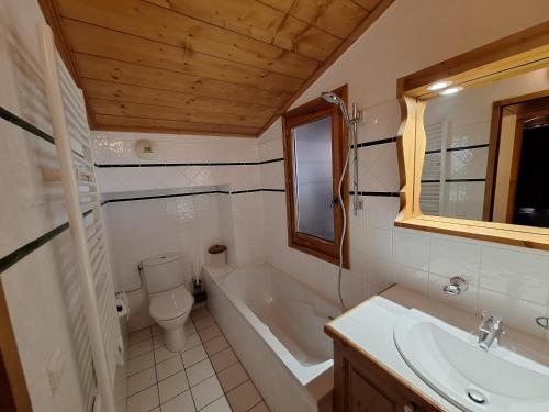 a bathroom with a tub and a toilet and a sink at Les Airelles A21 in Les Menuires