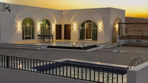 una villa con piscina y patio en Sunset77, en Al Wāşil
