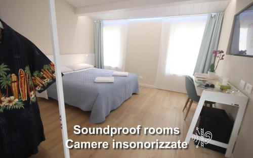 a bedroom with a bed and a desk and a mirror at Photomusic Boutique Rooms in Senigallia