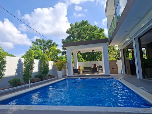 a swimming pool in the backyard of a house at Hermosa villa familiar cucu's home beach in Río San Juan