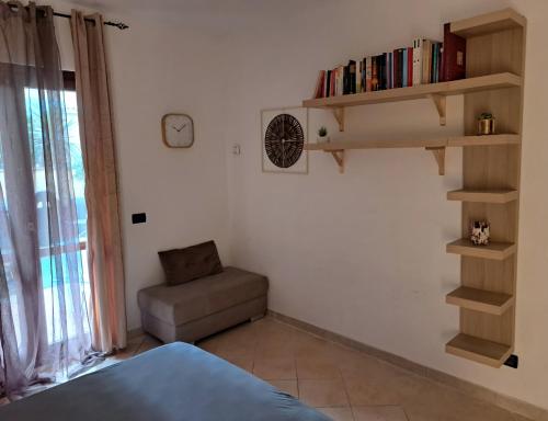 a room with a bed and a chair and a book shelf at Guest House Riva Tognazzi Casa Vacanze in Torvaianica