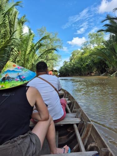 a group of people sitting on a boat in the water at Homestay Xóm Quê in Ấp Thành Hòa