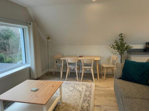 a living room with a table and chairs and a couch at Adalienes Retreat Flat 3 in Portree