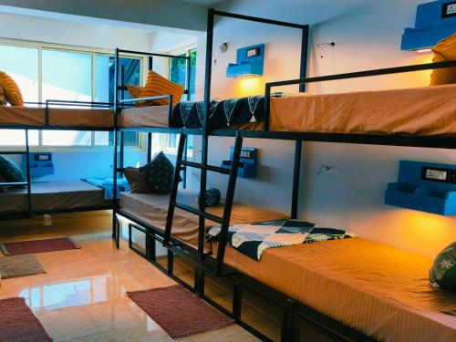 a room with three bunk beds and a couch at Mitra Palolem in Canacona