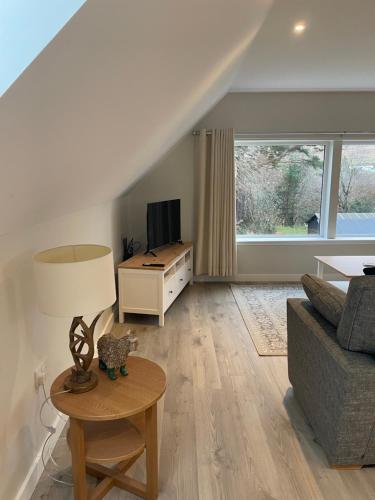 a living room with a couch and a table at Adalienes Retreat Flat 3 in Portree