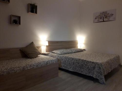 a hotel room with two beds and two lamps at Fontanarossa Airport Sleep and Travel 1 in CTA
