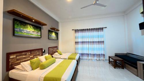 une chambre avec deux lits et une télévision à écran plat dans l'établissement Thinaya Lake Resort, à Anurâdhapura