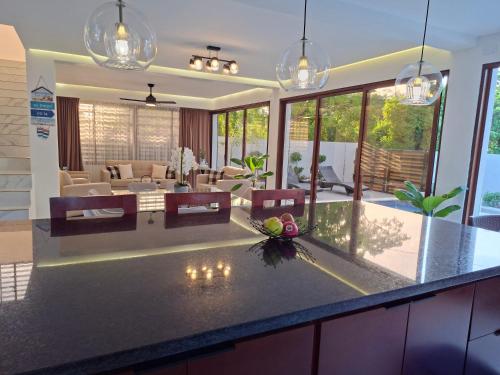 a kitchen with a counter top and a living room at Hermosa villa familiar cucu's home beach in Río San Juan