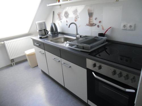 a kitchen with a sink and a stove at Ferienwohnung am Bodensee in Uhldingen-Mühlhofen