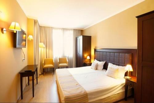 ein Hotelzimmer mit einem Bett und zwei Stühlen in der Unterkunft Royal Beach hotel Apartment Pool Sea B in Sonnenstrand