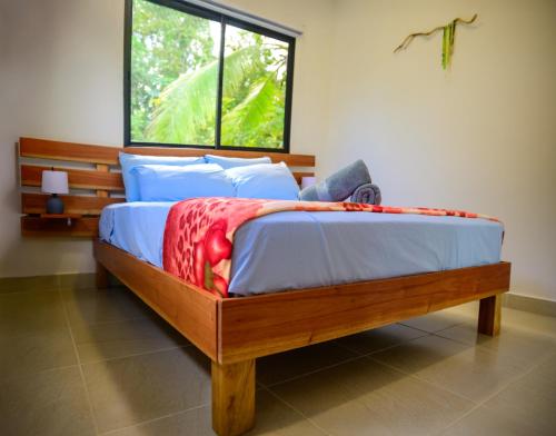 1 dormitorio con cama de madera y ventana en Villa Bruno - Jungle Lodge Near Corcovado & Puerto Jiménez, en Puerto Jiménez