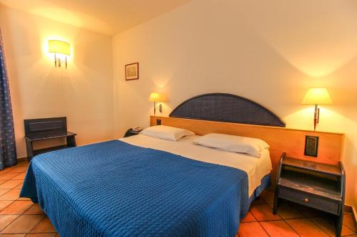 ランペドゥーザにあるホテル パラディーニ ディ フランシアのベッドルーム1室(大型ベッド1台、青い毛布付)