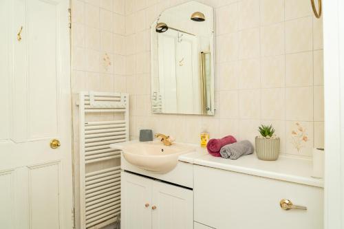 a white bathroom with a sink and a mirror at Luxury 4BR, Free Parking, Near Beach, Sleeps 8 in Edinburgh