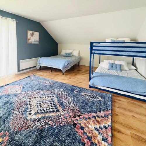 une chambre avec deux lits superposés et un tapis dans l'établissement La maison de la Baie, à Chambord
